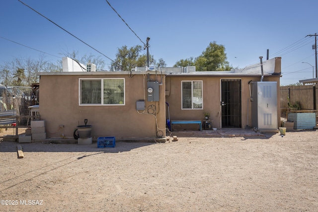 view of front of house featuring fence and stucco siding