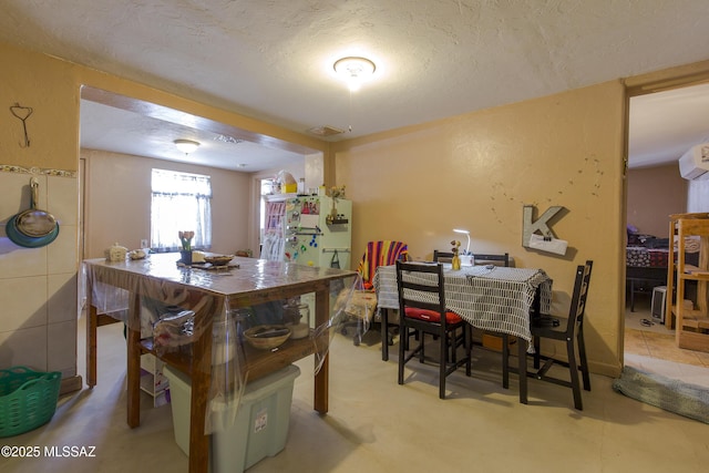 dining space with visible vents and a textured ceiling