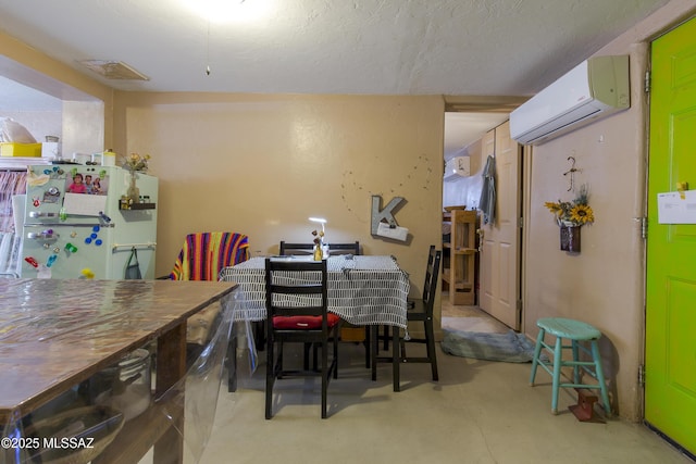 dining space with an AC wall unit, visible vents, and concrete floors