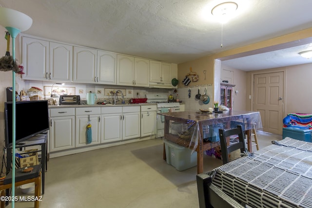 kitchen with under cabinet range hood, a textured ceiling, white range with gas stovetop, and a sink