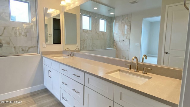 bathroom with a wealth of natural light, walk in shower, and a sink