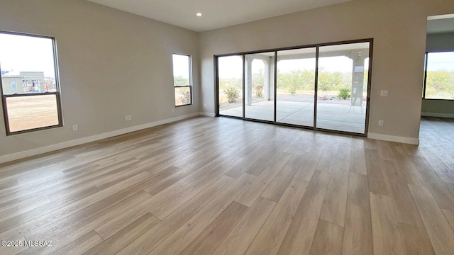 spare room with recessed lighting, light wood-type flooring, and baseboards