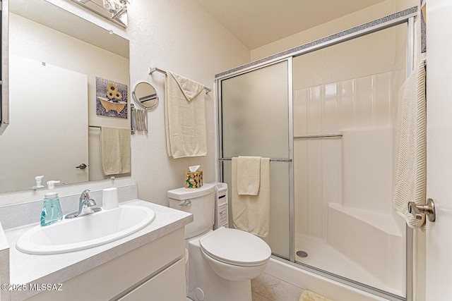 full bathroom featuring toilet, a stall shower, and vanity