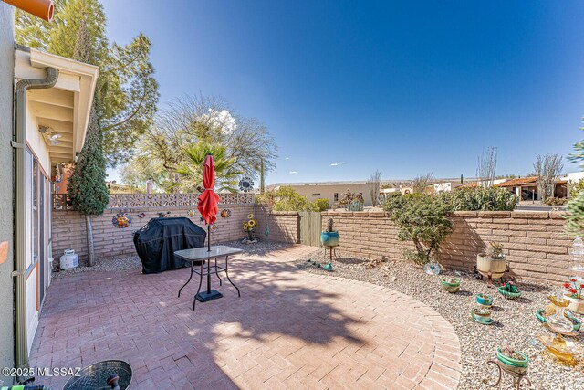 view of patio with area for grilling and a fenced backyard