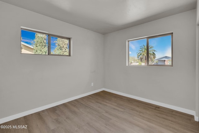 empty room featuring wood finished floors and baseboards