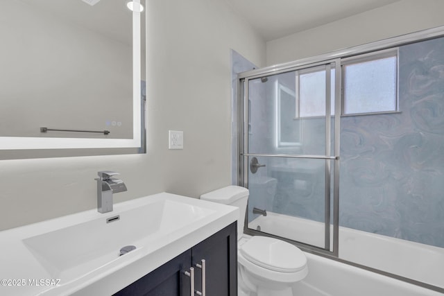 full bathroom with toilet, vanity, and shower / bath combination with glass door