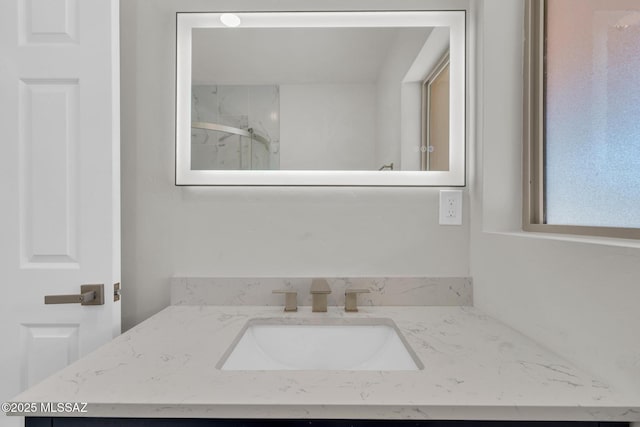 bathroom featuring a marble finish shower and vanity