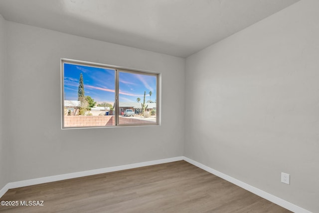 empty room featuring baseboards and wood finished floors