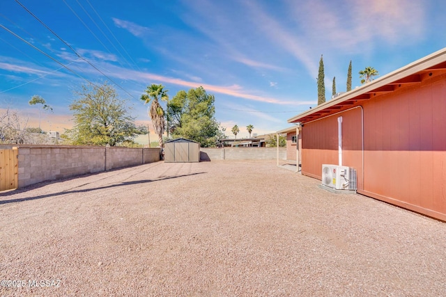 view of yard featuring an outdoor structure, ac unit, a storage unit, and fence