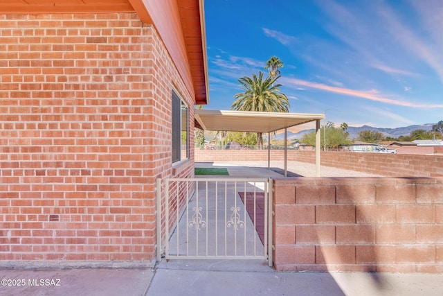 exterior space featuring a mountain view, fence, and a gate