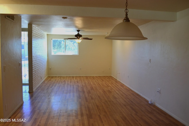 unfurnished room with visible vents, baseboards, a ceiling fan, and wood finished floors