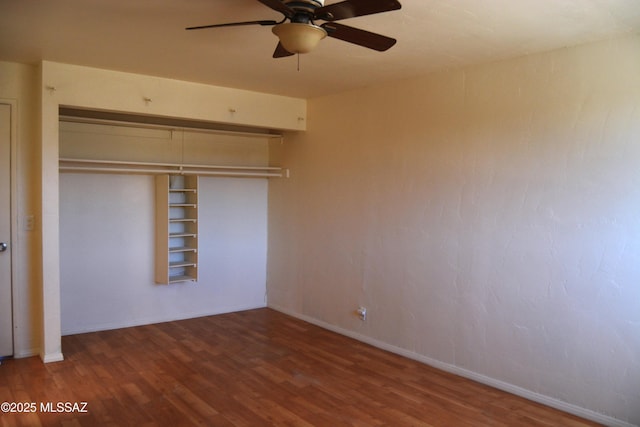unfurnished bedroom featuring a closet, baseboards, ceiling fan, and wood finished floors