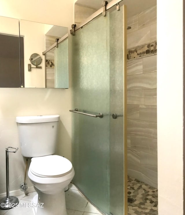 full bath with tile patterned floors, toilet, and a shower stall