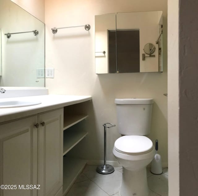 bathroom featuring toilet, vanity, baseboards, and tile patterned flooring