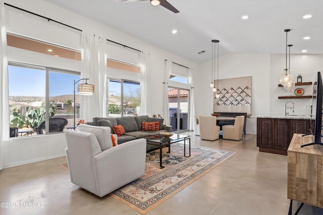 living area with visible vents, ceiling fan, finished concrete floors, recessed lighting, and high vaulted ceiling