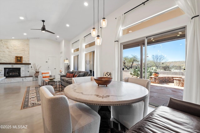 dining room featuring visible vents, high vaulted ceiling, a ceiling fan, recessed lighting, and a stone fireplace