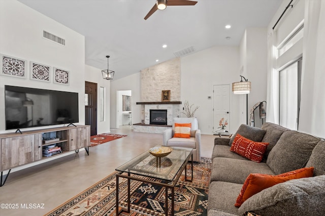 living room with a fireplace, a ceiling fan, visible vents, and high vaulted ceiling