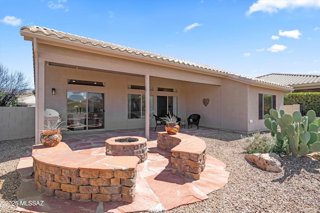 back of property with a patio, fence, an outdoor fire pit, stucco siding, and a tile roof