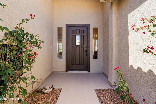 entrance to property featuring stucco siding