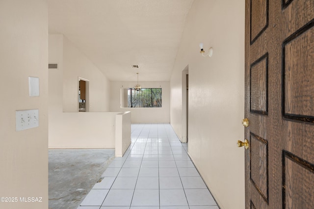 hall with light tile patterned floors, visible vents, and vaulted ceiling