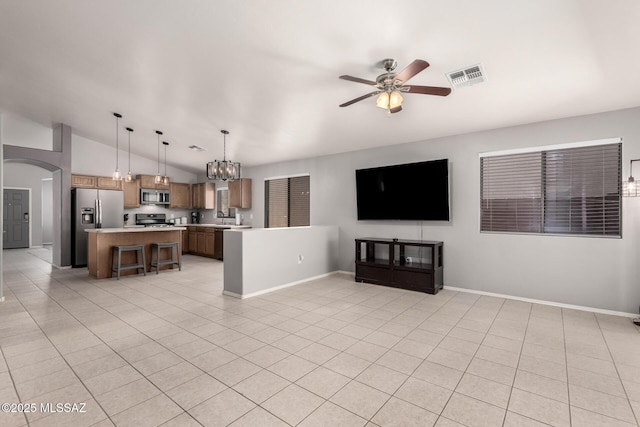 unfurnished living room featuring visible vents, lofted ceiling, ceiling fan with notable chandelier, arched walkways, and light tile patterned flooring