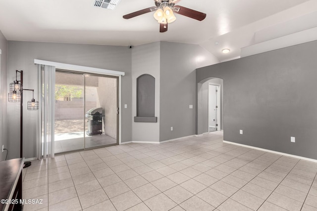 unfurnished room featuring visible vents, a ceiling fan, arched walkways, light tile patterned flooring, and vaulted ceiling