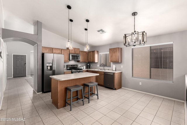 kitchen with visible vents, a sink, stainless steel appliances, arched walkways, and light countertops