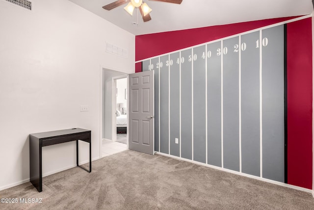 unfurnished bedroom featuring visible vents, ceiling fan, lofted ceiling, and carpet floors