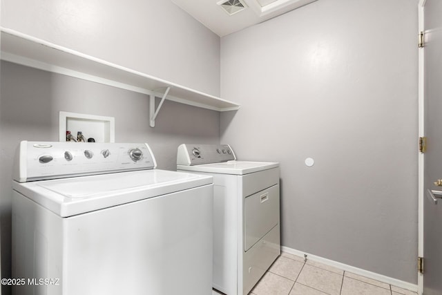 laundry area featuring visible vents, washing machine and dryer, light tile patterned floors, baseboards, and laundry area