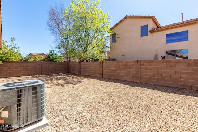 view of yard with central AC unit and a fenced backyard