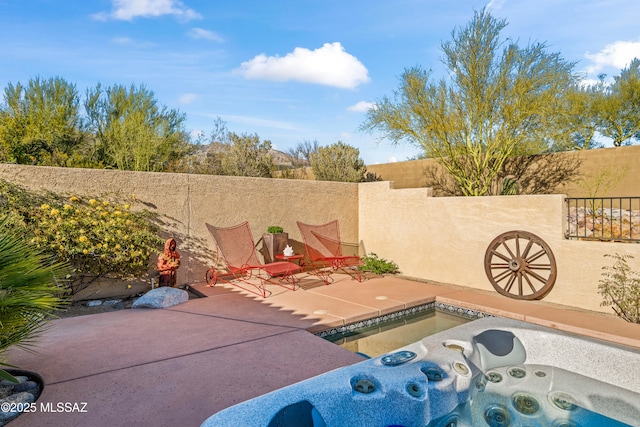 view of patio featuring fence and an outdoor hot tub