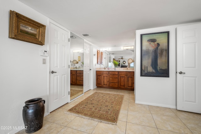 bathroom featuring baseboards, visible vents, tile patterned flooring, and vanity
