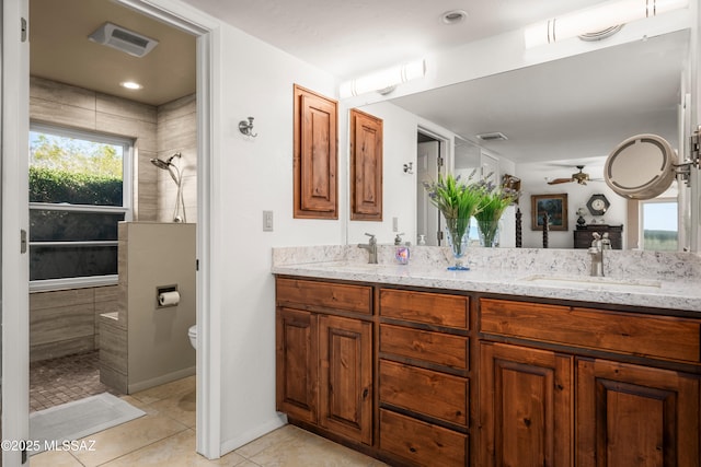 bathroom with visible vents, a sink, tile patterned flooring, and a tile shower