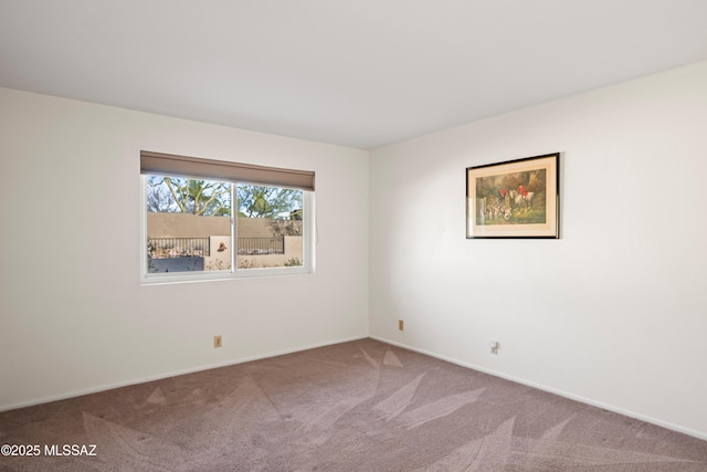 carpeted spare room featuring baseboards