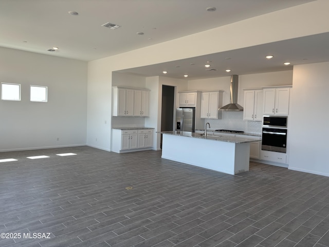 14722 E Sands Ranch Rd, Vail, AZ 85641 - kitchen featuring stainless steel appliances, wall chimney range hood, open floor plan, tasteful backsplash, and a kitchen island with sink