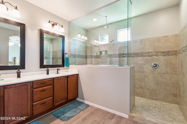 bathroom with double vanity, wood finished floors, and a walk in shower