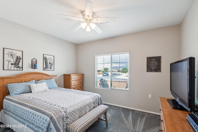 bedroom featuring baseboards, dark colored carpet, and ceiling fan