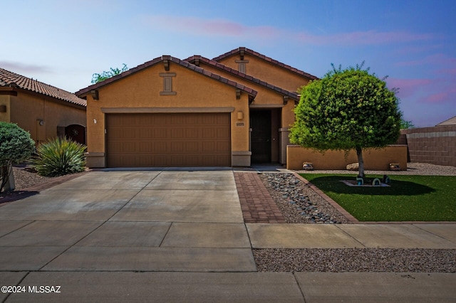 view of front of home with fence, an attached garage, a yard, stucco siding, and concrete driveway