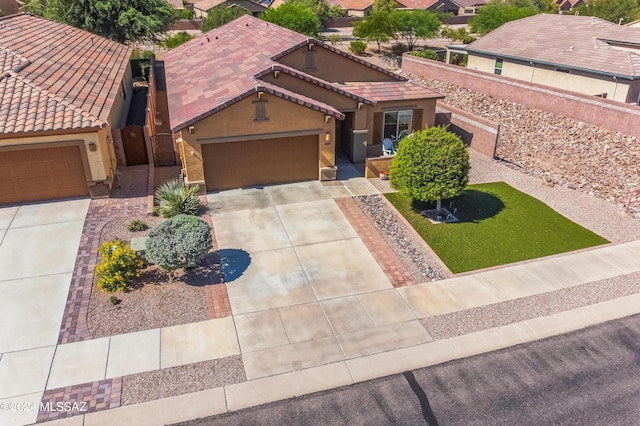 view of front facade with a tiled roof, a garage, driveway, and stucco siding