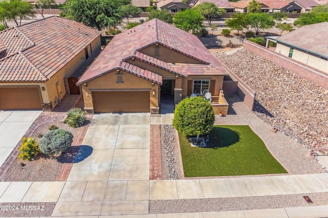 view of front facade featuring stucco siding, driveway, a tile roof, and a garage