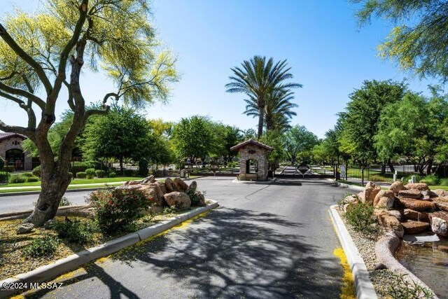 view of road with a gate, curbs, and a gated entry