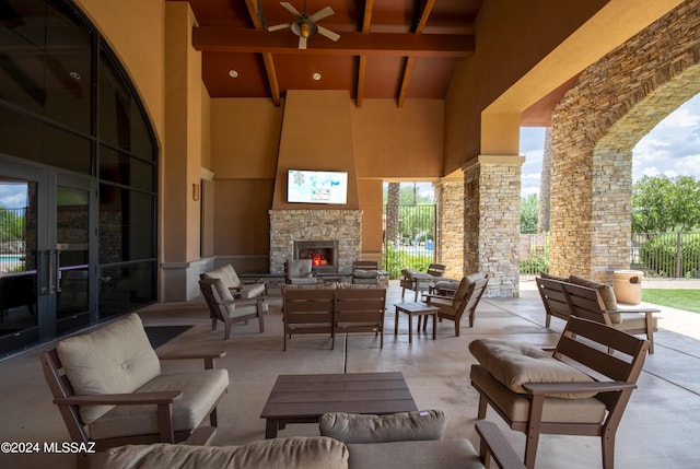 view of patio / terrace featuring french doors, an outdoor living space with a fireplace, and fence