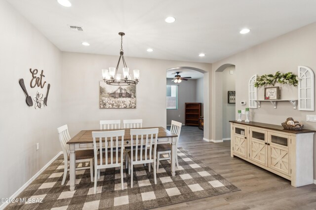 dining room featuring recessed lighting, visible vents, arched walkways, and wood finished floors