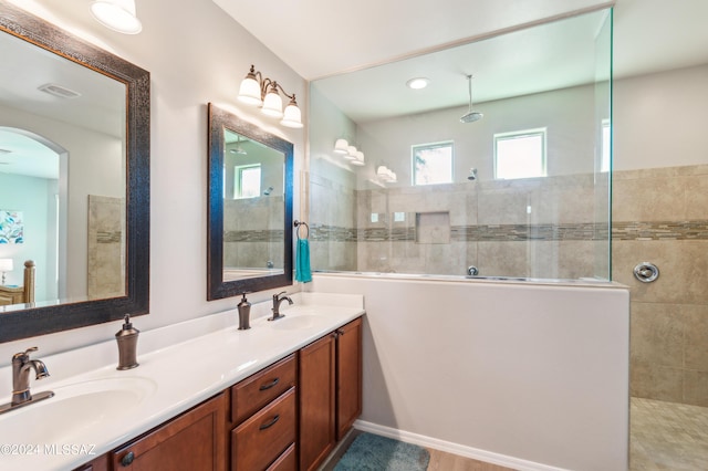 bathroom featuring a sink, visible vents, walk in shower, and double vanity