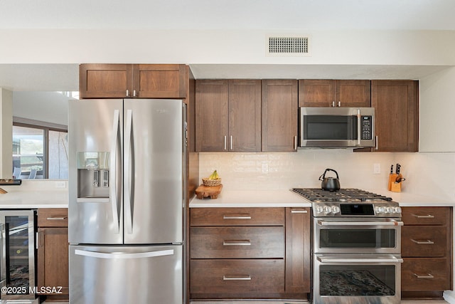 kitchen featuring decorative backsplash, wine cooler, visible vents, and appliances with stainless steel finishes