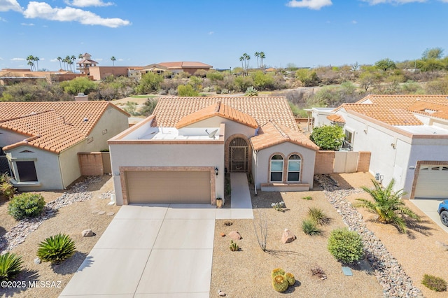 view of front of property featuring fence, a tile roof, concrete driveway, stucco siding, and a garage