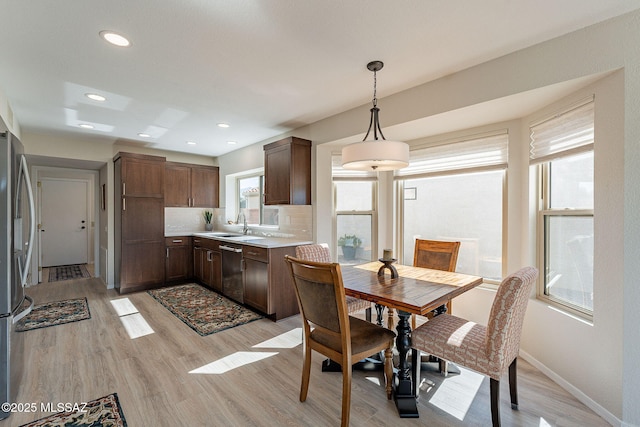 dining space featuring recessed lighting, baseboards, and light wood finished floors