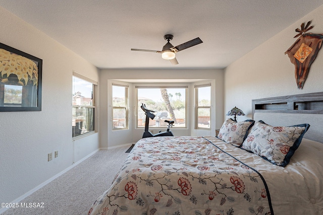 carpeted bedroom with ceiling fan, a textured ceiling, and baseboards