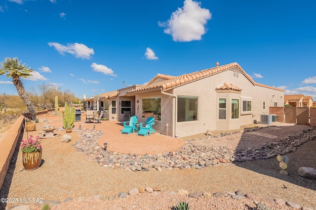 back of house featuring a fenced backyard, central AC, stucco siding, a tiled roof, and a patio area