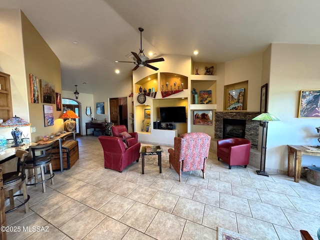 tiled living area featuring high vaulted ceiling, built in shelves, a fireplace, and a ceiling fan